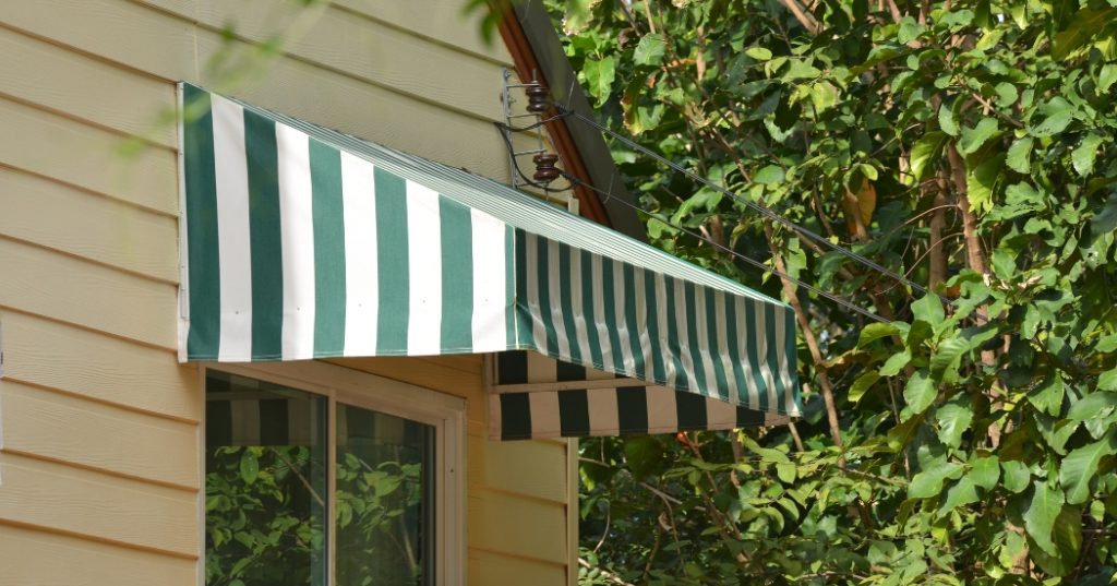 A green and white awning installed on the wall